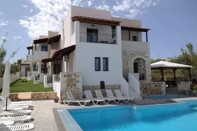 a villa with a swimming pool in front of a house at Ledra Maleme Hotel in Maleme
