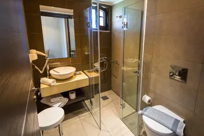 a bathroom with a toilet and a sink and a shower at Ledra Maleme Hotel in Maleme