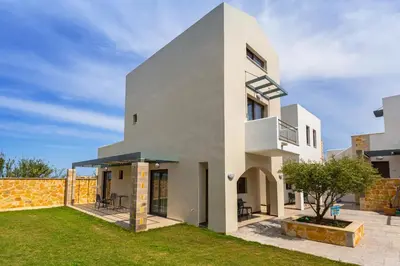 a white house with a lawn in front of it at Ledra Maleme Hotel in Maleme
