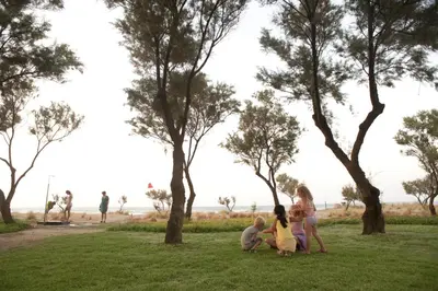 a family sitting on the grass in a park at Lito Beach Hotel in Gerani Chanion