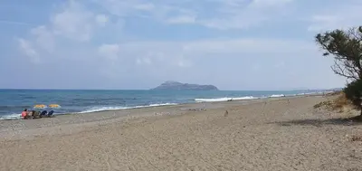a group of people sitting on a beach near the ocean at Lito Beach Hotel in Gerani Chanion
