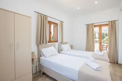 two beds in a white room with a window at Villa Andromeda Fres in Frés