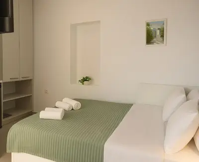 a white bedroom with a bed with towels on it at Yalos Tiny Studio - 5 mins to Elafonisi beach in Agios Padeleimon