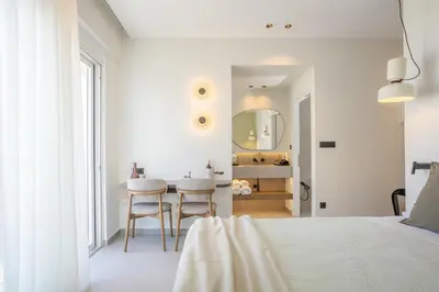 a bedroom with a bed and a table and a mirror at Eftihia Studios Paleochora in Palaiochóra