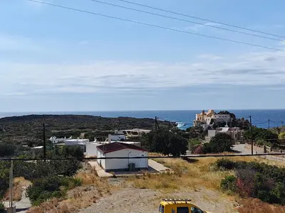 a yellow school bus parked on a hill near the ocean at Chrissos apartment in Agios Padeleimon