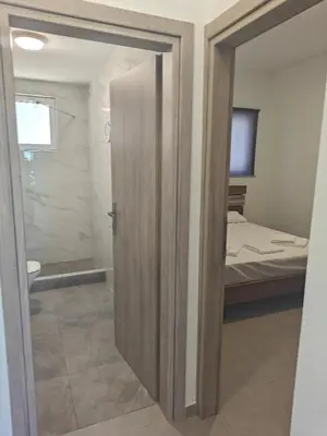 a bathroom with a door leading to a bedroom at Chrissos apartment in Agios Padeleimon