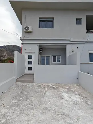 a white house with a white fence in front of it at Chrissos apartment in Agios Padeleimon