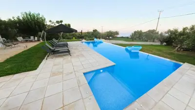 a swimming pool with blue water in a yard at MG Residence Boutique Holiday Home in Korakiaí