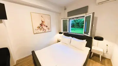 a bedroom with a white bed and a window at MG Residence Boutique Holiday Home in Korakiaí