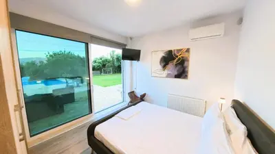 a bedroom with a large window and a bed at MG Residence Boutique Holiday Home in Korakiaí