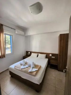 a bedroom with a bed with two towels on it at Tarra Rooms and Apartments in Agia Roumeli