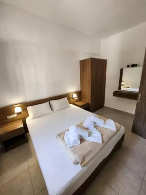 a bedroom with a white bed with towels on it at Tarra Rooms and Apartments in Agia Roumeli
