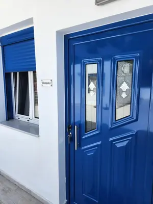 a blue door and a window on a building at Tarra Rooms and Apartments in Agia Roumeli