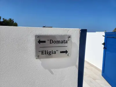 a sign on a wall that says dominica and elipedia at Tarra Rooms and Apartments in Agia Roumeli