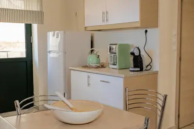 a kitchen with a white refrigerator and a bowl on a table at Maisonette in Koumpeli in Koumpeli