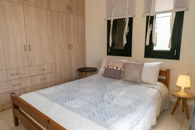 a bedroom with a bed with a blue comforter at Maisonette in Koumpeli in Koumpeli