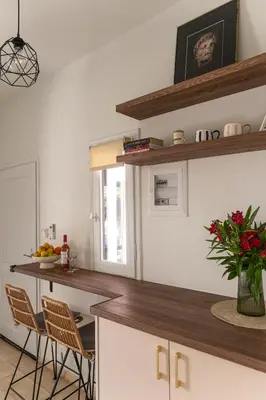 a kitchen with a counter with chairs and a table at Central Kalyves Appartment - 5 min waking to the beach in Kalyves