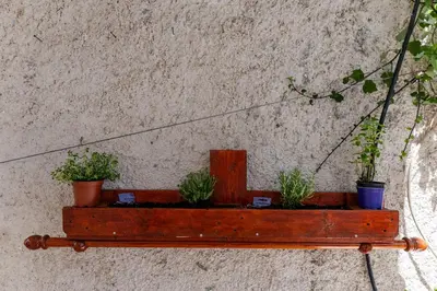 a wooden shelf with potted plants on a wall at Central Kalyves Appartment - 5 min waking to the beach in Kalyves