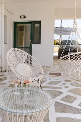 a group of white chairs and tables on a patio at Central Kalyves Appartment - 5 min waking to the beach in Kalyves