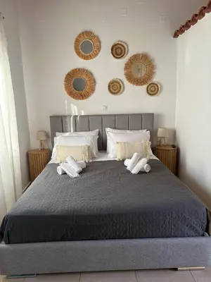 a bedroom with a large bed with mirrors on the wall at Semeli House in Chania Town