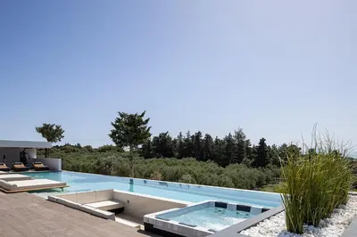 a swimming pool with two lounge chairs and a swimming pool at Versante Rousso - Modern Living in Nature's Embrace by etouri in Káïna