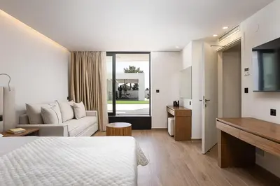 a hotel room with a bed and a couch at Versante Rousso - Modern Living in Nature's Embrace by etouri in Káïna