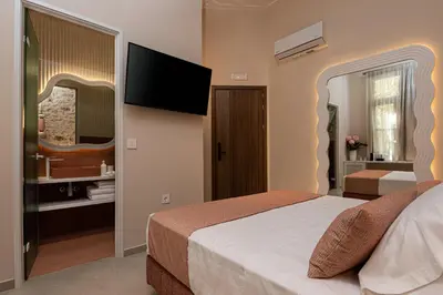 a bedroom with a bed with a television on the wall at Madonna del Mare City in Chania Town