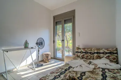 a bedroom with a bed and a table and a window at Cretan Blue Bungalow Chania in Chania Town