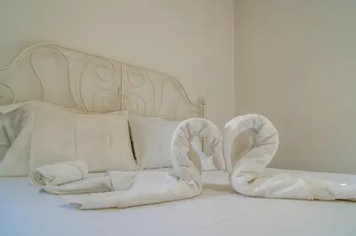 a bed with white towels on top of it at Cretan Blue Bungalow Chania in Chania Town