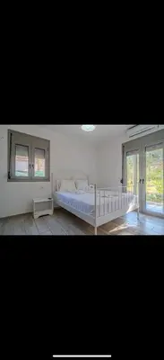 a white bedroom with a bed and a window at Cretan Blue Bungalow Chania in Chania Town