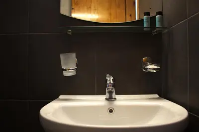 a white sink in a bathroom with a mirror at EYTYXHS Studios in Palaiochóra