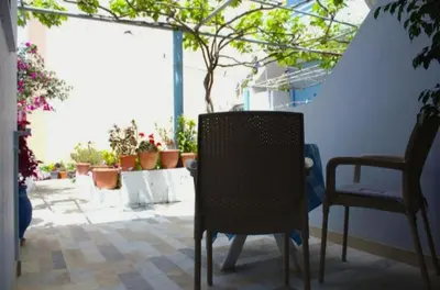 a table and chairs in a room with plants at EYTYXHS Studios in Palaiochóra