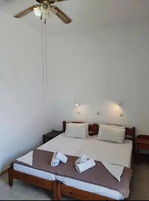 a bedroom with a bed with two towels on it at EYTYXHS Studios in Palaiochóra