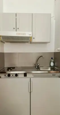 a kitchen with white cabinets and a sink at EYTYXHS Studios in Palaiochóra
