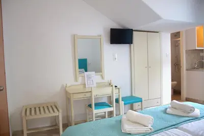 a room with a bed and a desk and a mirror at EYTYXHS Studios in Palaiochóra