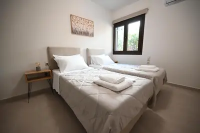 two beds in a room with white sheets and towels at Unick Avra Luxury Living in Kalathas