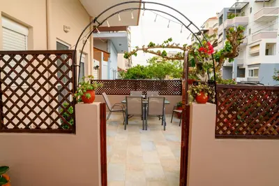 a patio with a table and chairs on a balcony at Happy House-Steps from Nea Chora Beach in Chania Town