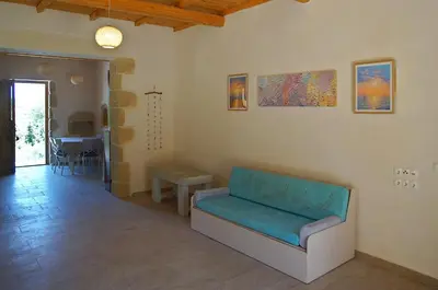 a living room with a couch and a table at The Village Hideaway - Traditional Stone House in Kissamos