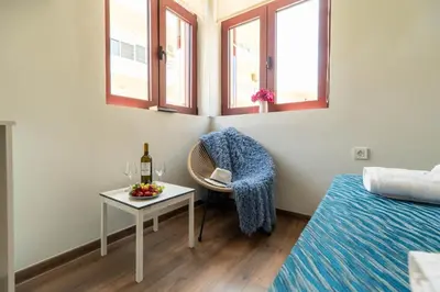 a room with a chair and a table with a bottle of wine at Casa Chris in Chania Town