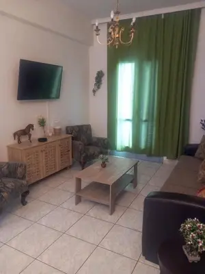 a living room with a couch and a table and a television at Emmanouil in Chania Town