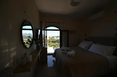 a bedroom with two beds and an open window at Unick Seaview Luxury Living in Kalathas