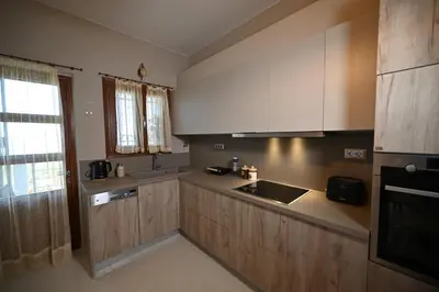 a kitchen with wooden cabinets and a sink and a window at Unick Seaview Luxury Living in Kalathas