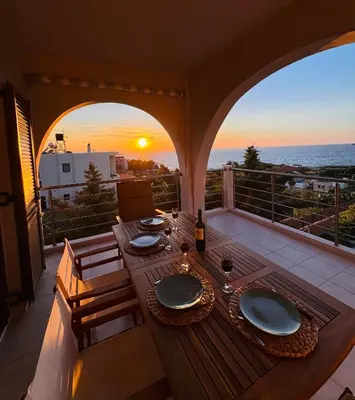 a table on a balcony with a view of the ocean at Unick Seaview Luxury Living in Kalathas