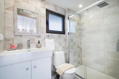 a bathroom with a toilet and a sink and a shower at Slavena Suite in Perivólia