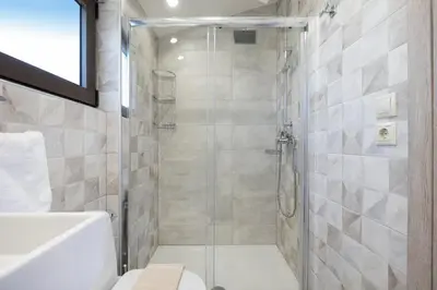 a bathroom with a shower with a glass door at Slavena Suite in Perivólia