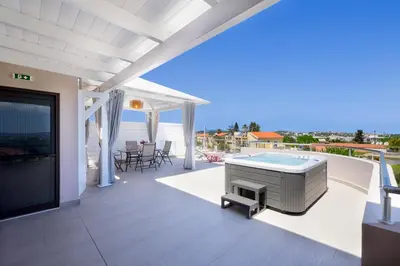 a patio with a pool and a tv on a roof at Slavena Suite in Perivólia