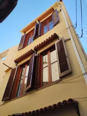 a building with windows and shutters on it at Lili House in Chania Town