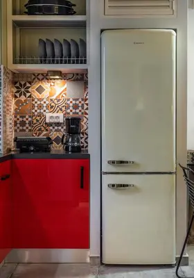 a white refrigerator in a kitchen with red cabinets at Cosy 1st floor apartment at Koum Kapi Beach in Chania Town