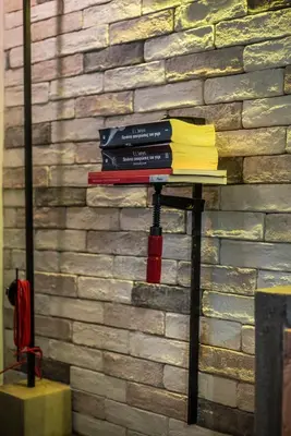 a stack of books on a stand in front of a brick wall at Cosy 1st floor apartment at Koum Kapi Beach in Chania Town
