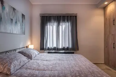 a bedroom with a large bed and a window at Cosy 1st floor apartment at Koum Kapi Beach in Chania Town